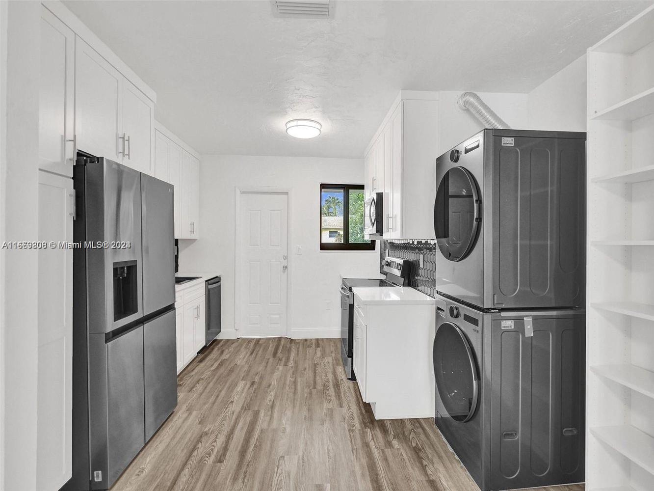 a kitchen with a refrigerator a washer and dryer