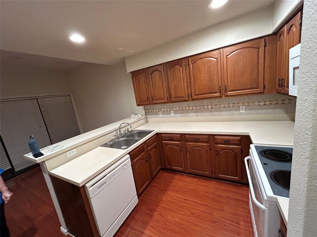 a kitchen with granite countertop a sink a stove and cabinets