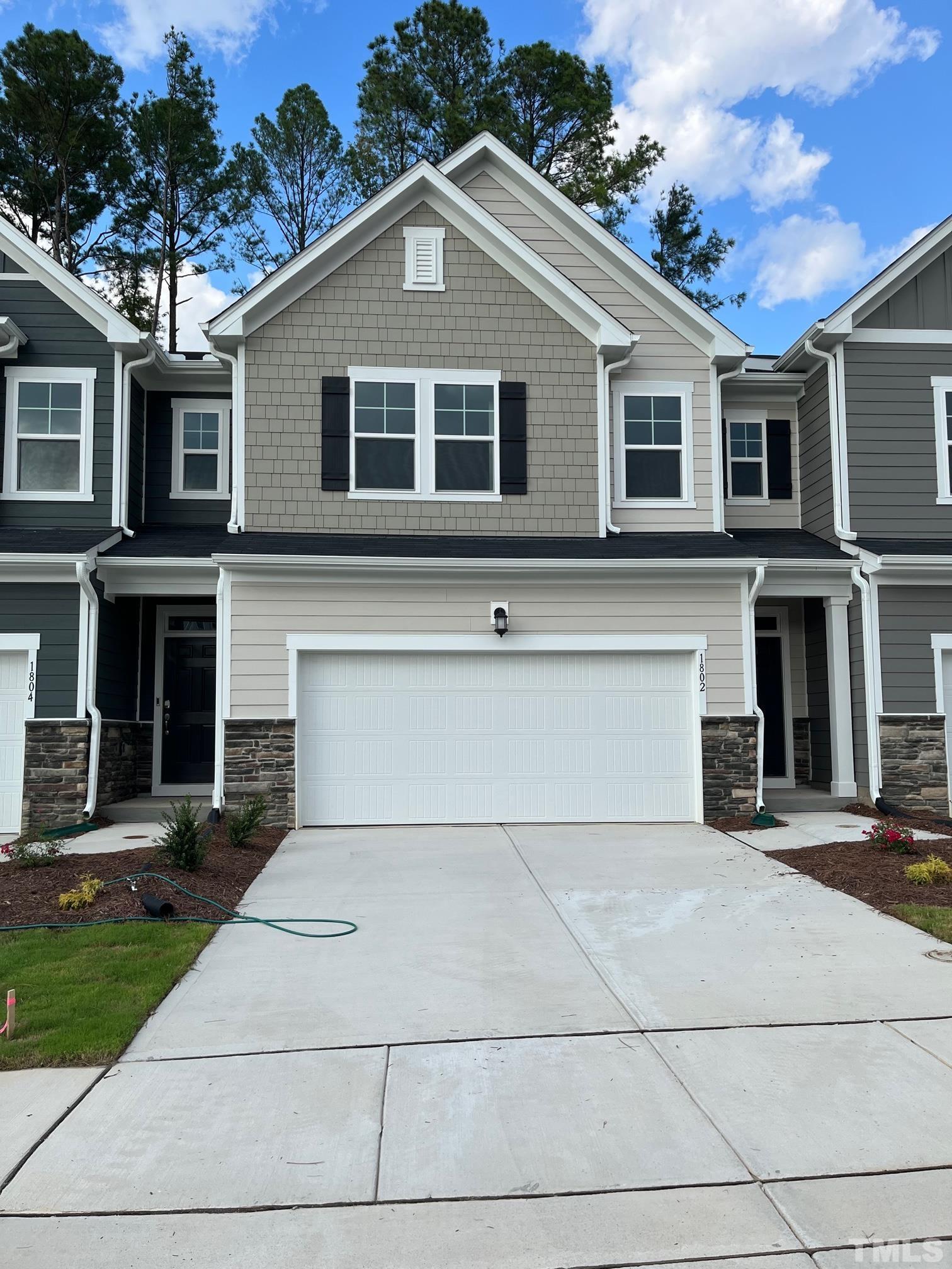 a front view of a house with yard and parking