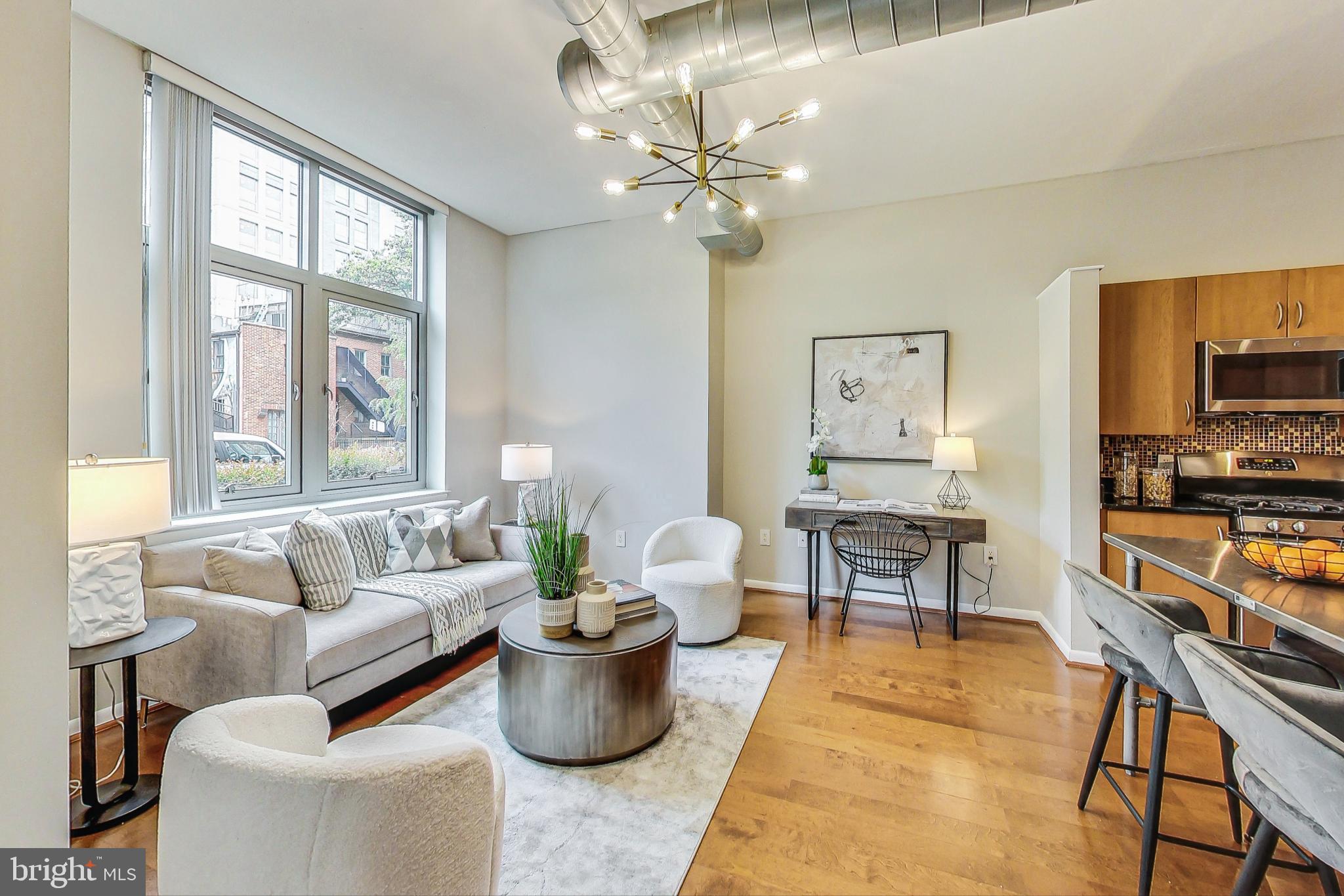 a living room with furniture a chandelier and a flat screen tv