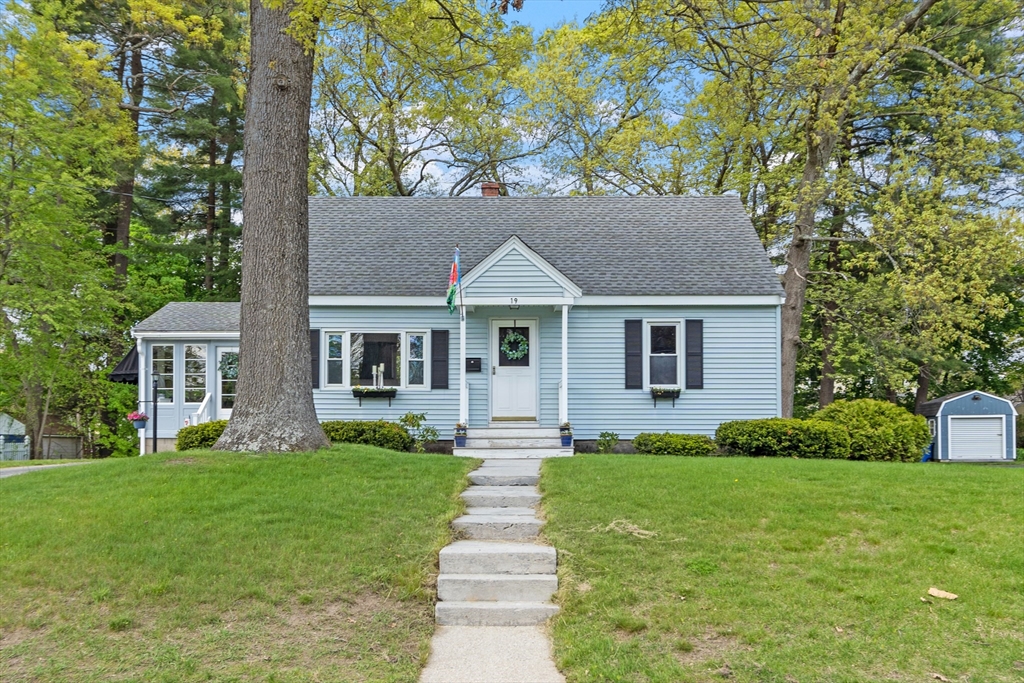 a front view of a house with a yard and trees