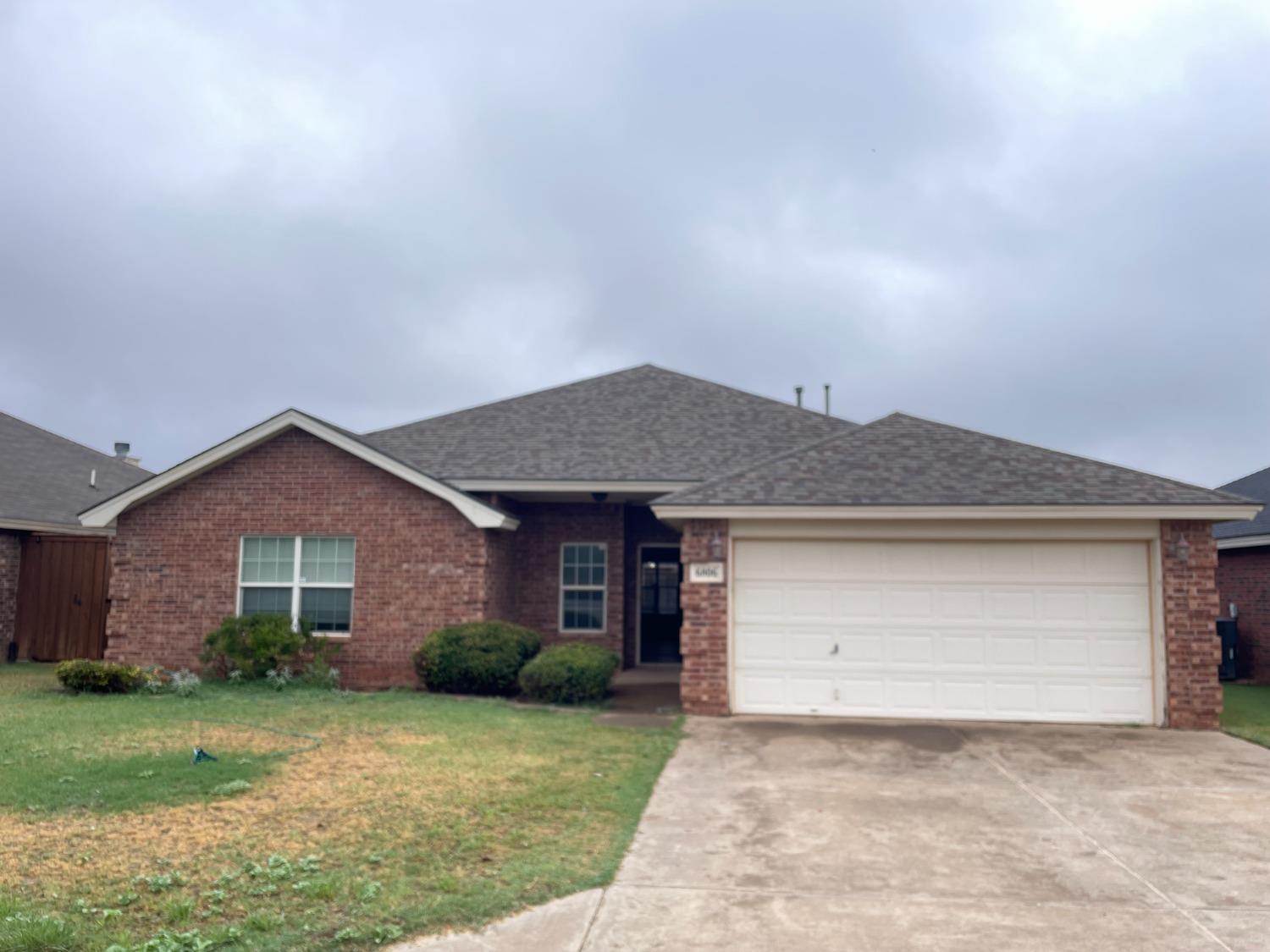 a front view of a house with a garden and yard