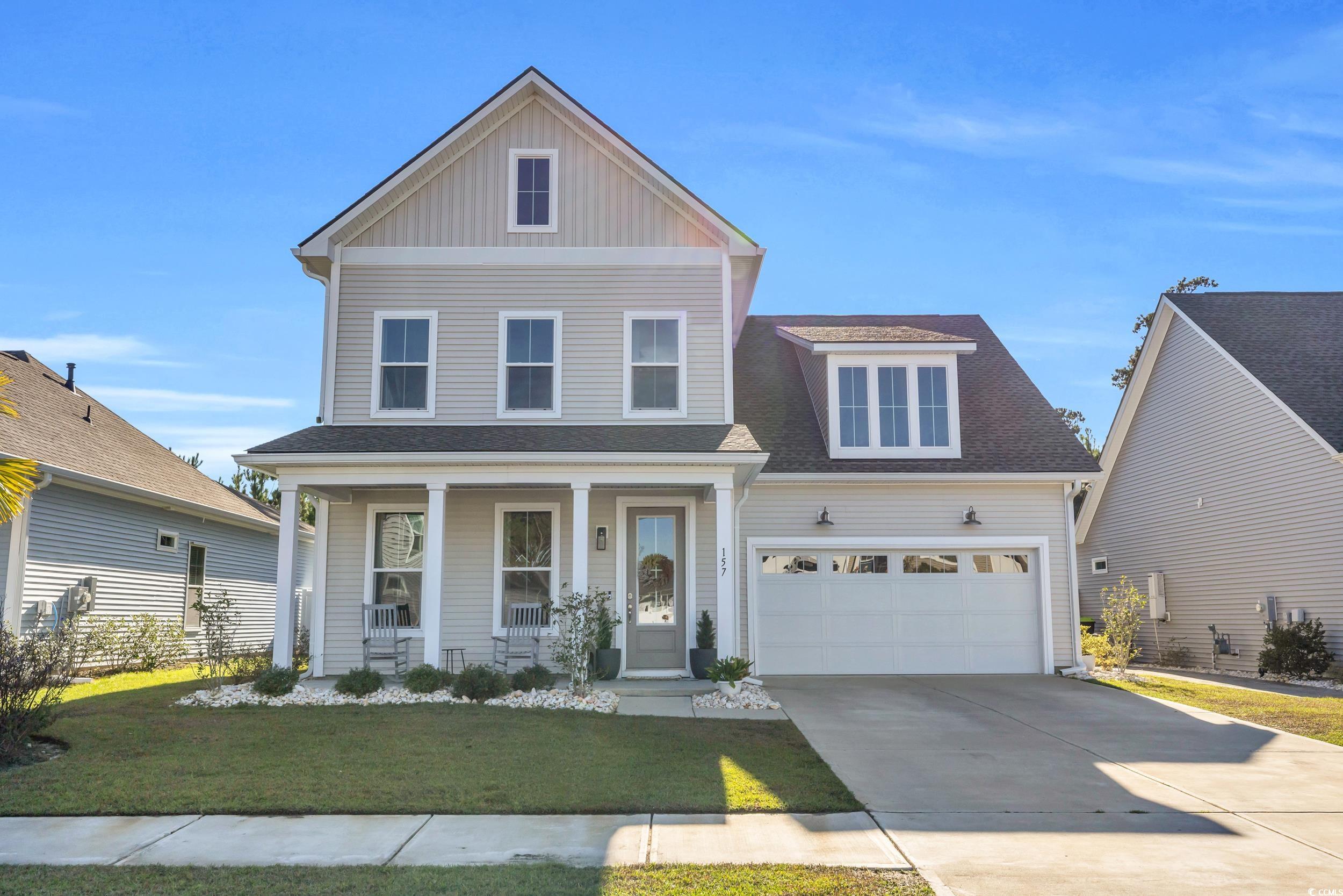 View of front of house featuring a front lawn, a g