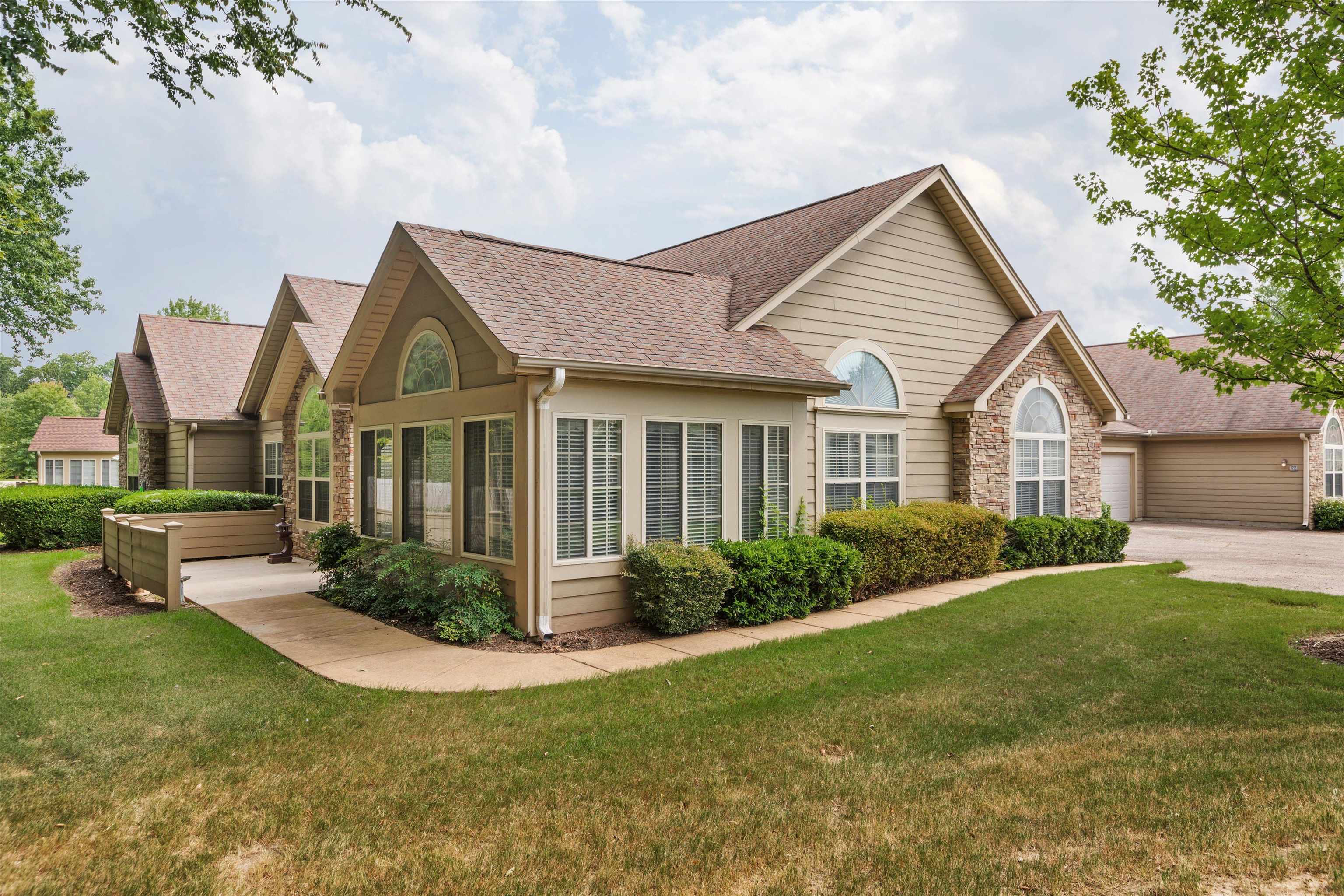 a front view of a house with a yard and trees