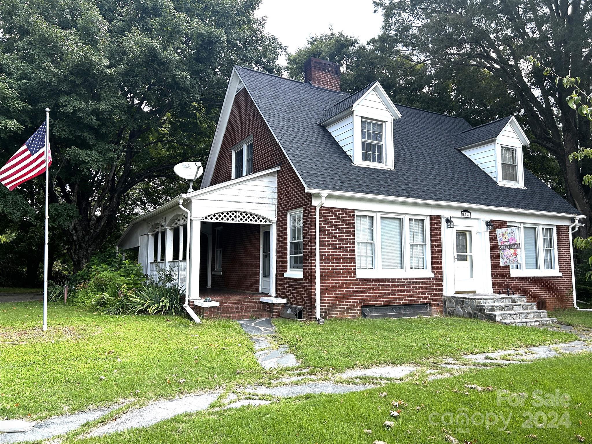 a front view of a house with a garden and yard