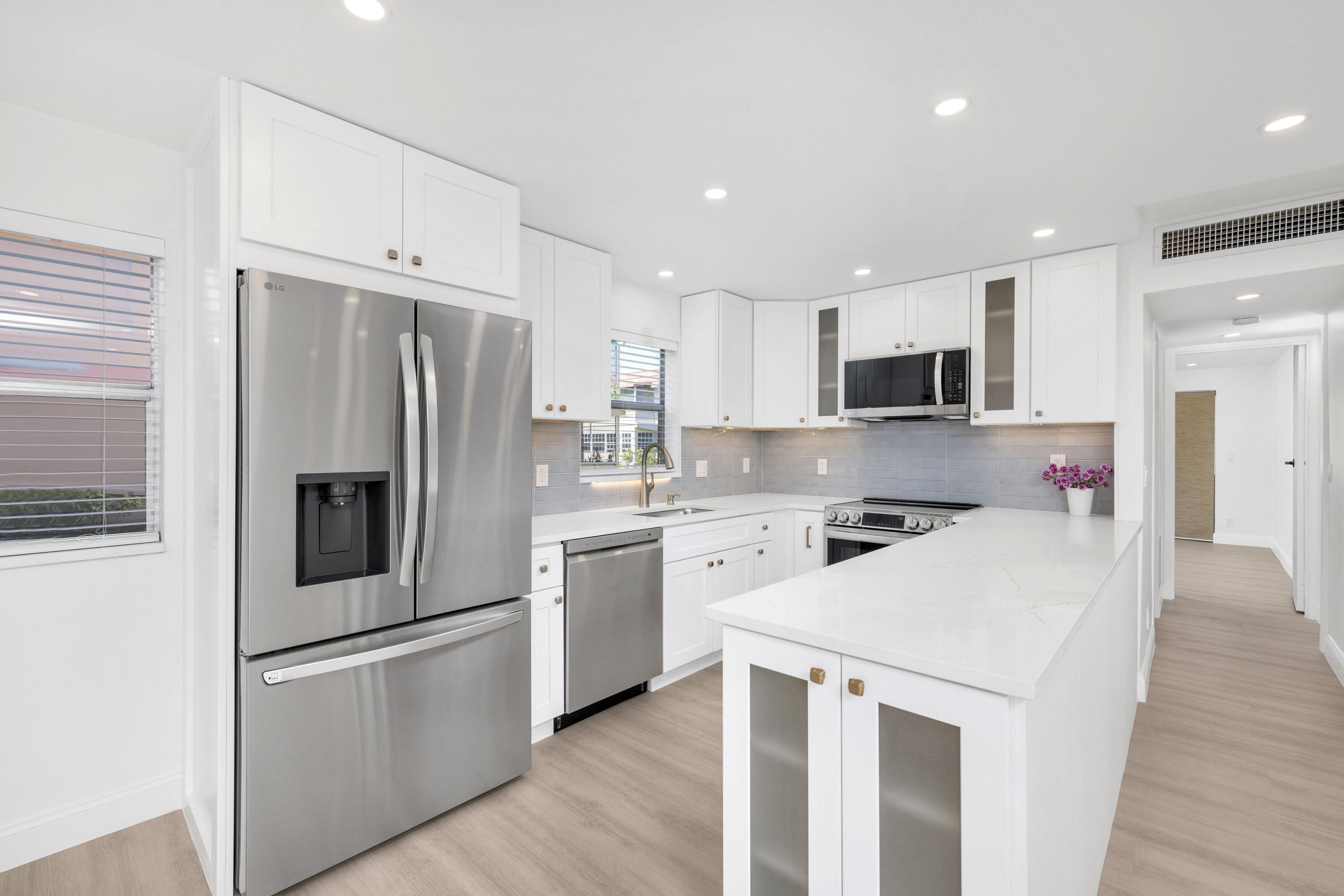 a kitchen with stainless steel appliances a refrigerator sink and microwave