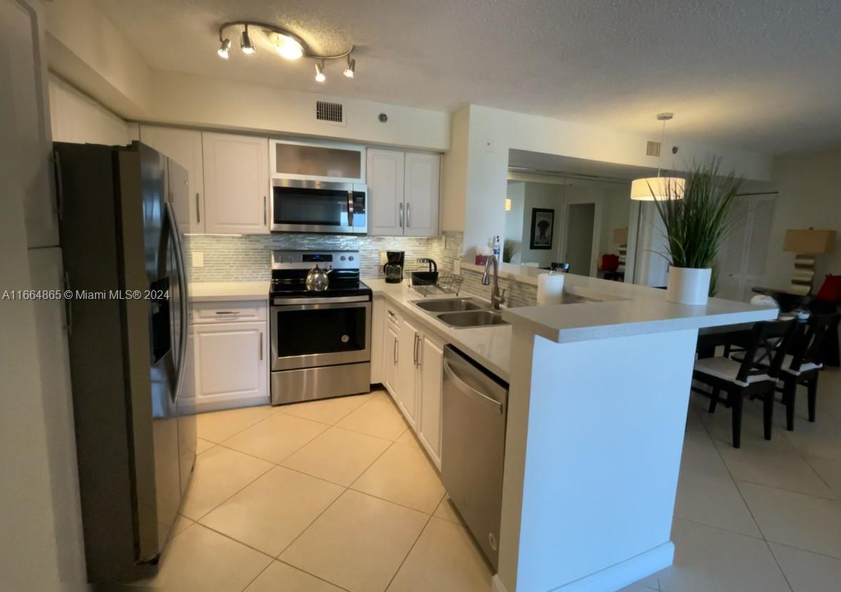 a kitchen with stainless steel appliances granite countertop a refrigerator and a stove