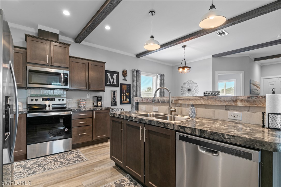 a kitchen with stainless steel appliances granite countertop a sink and stove top oven