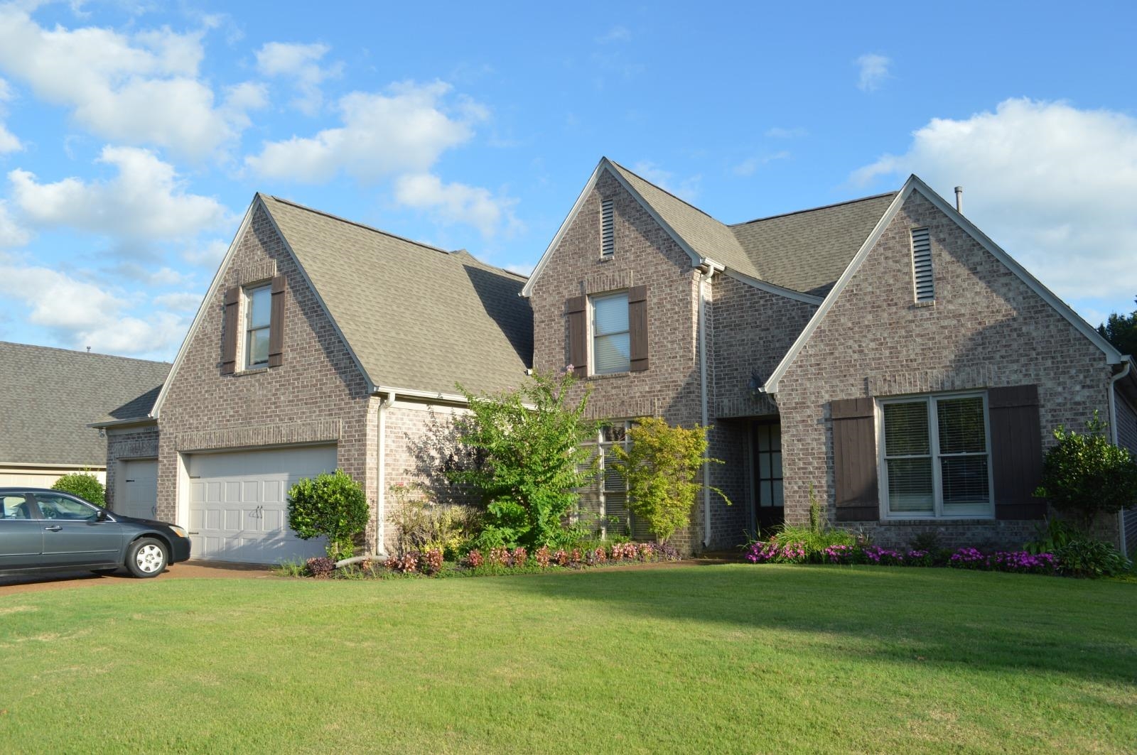 a front view of a house with a garden and yard