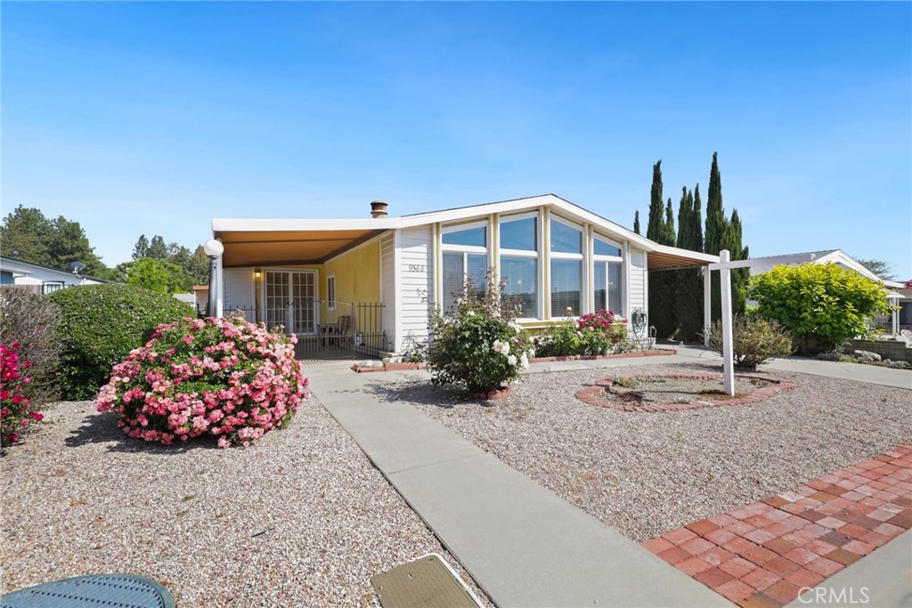 a front view of a house with a yard and potted plants