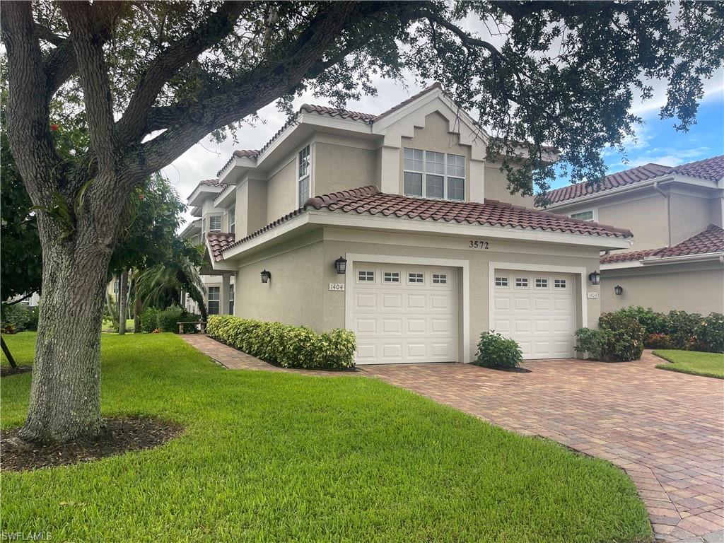 View of front of property with a garage and a front lawn