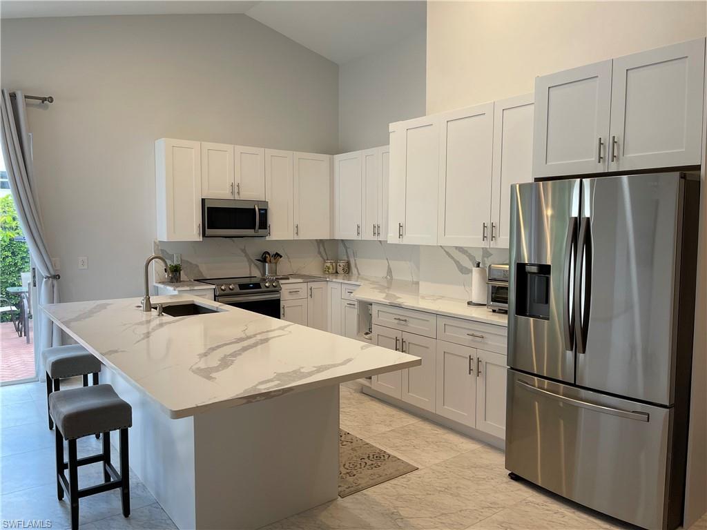 a kitchen with stainless steel appliances a refrigerator stove microwave and sink