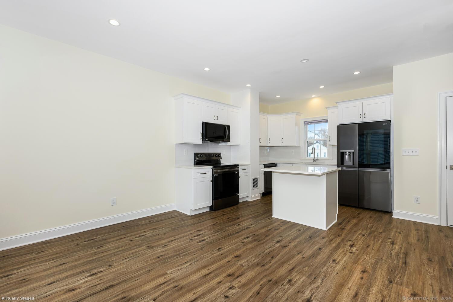 a kitchen with a refrigerator and white cabinets