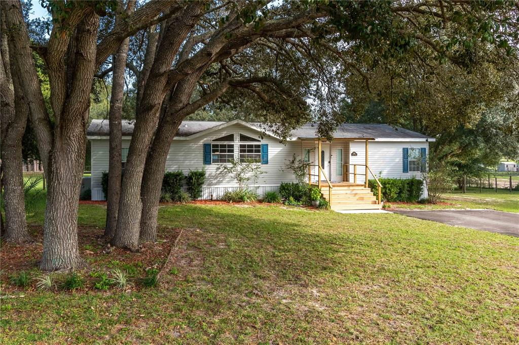 a front view of a house with yard and green space