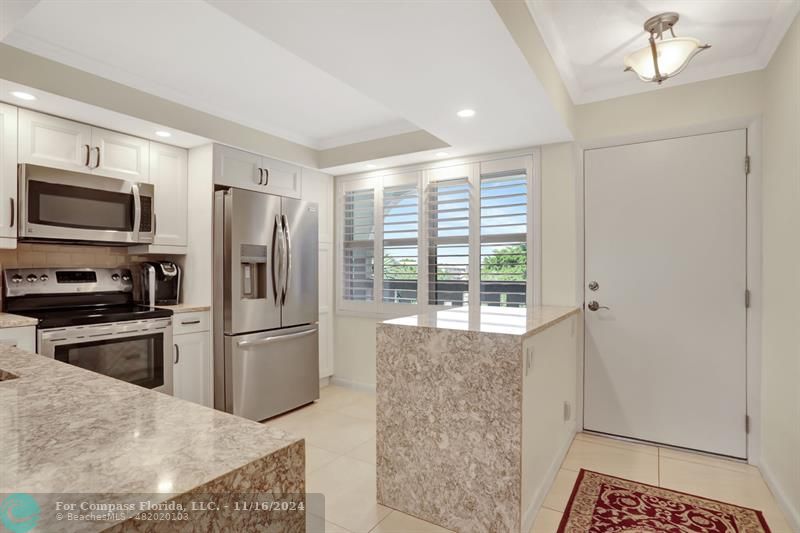 a kitchen with a refrigerator microwave and stove top oven