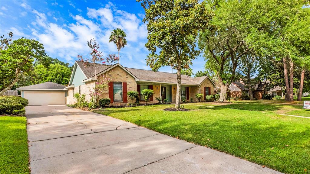 Nice lush green front lawn with long driveway