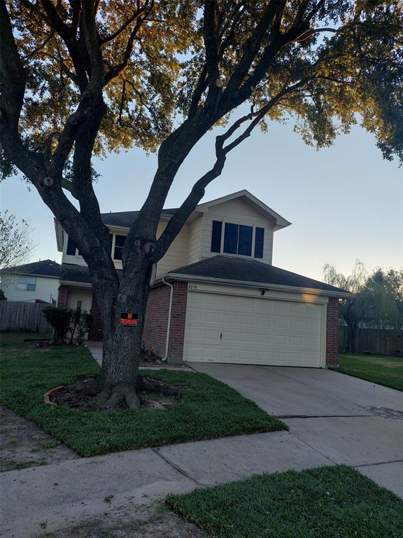 a front view of a house with a garden and trees