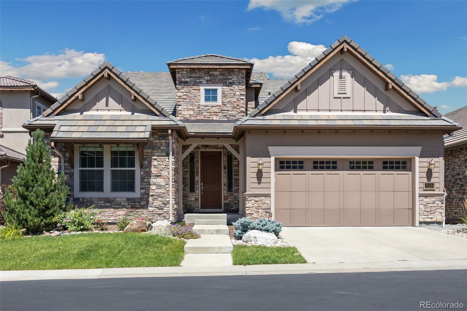 a front view of a house with a yard and garage