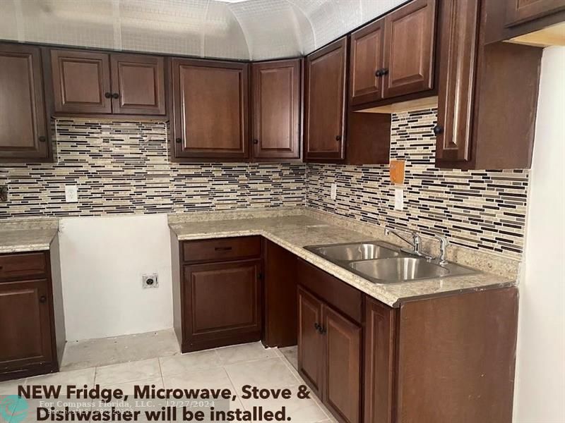 a kitchen with stainless steel appliances granite countertop a sink stove and cabinets