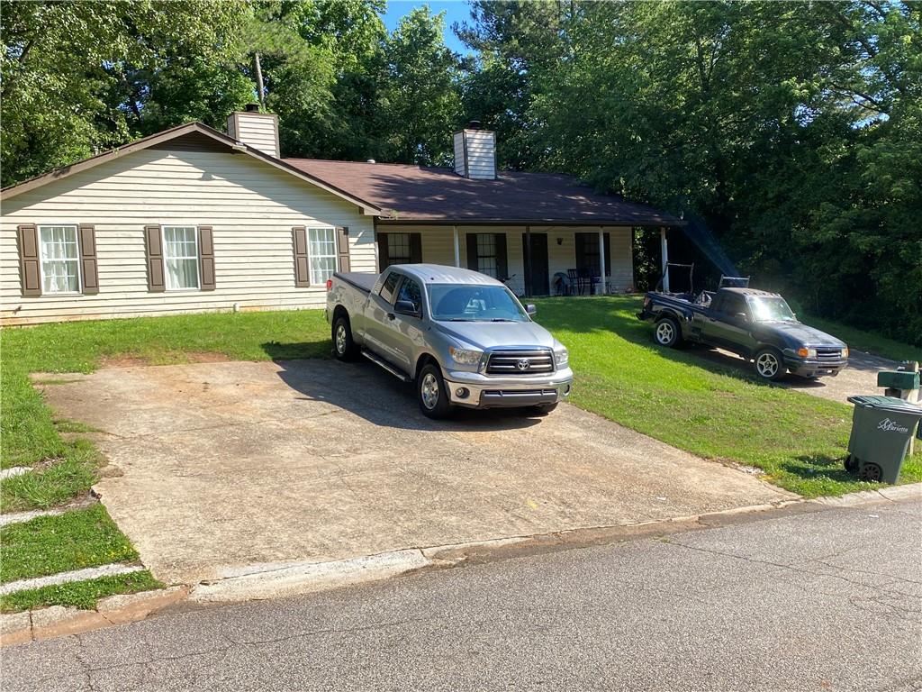 a front view of a house with a garden and yard