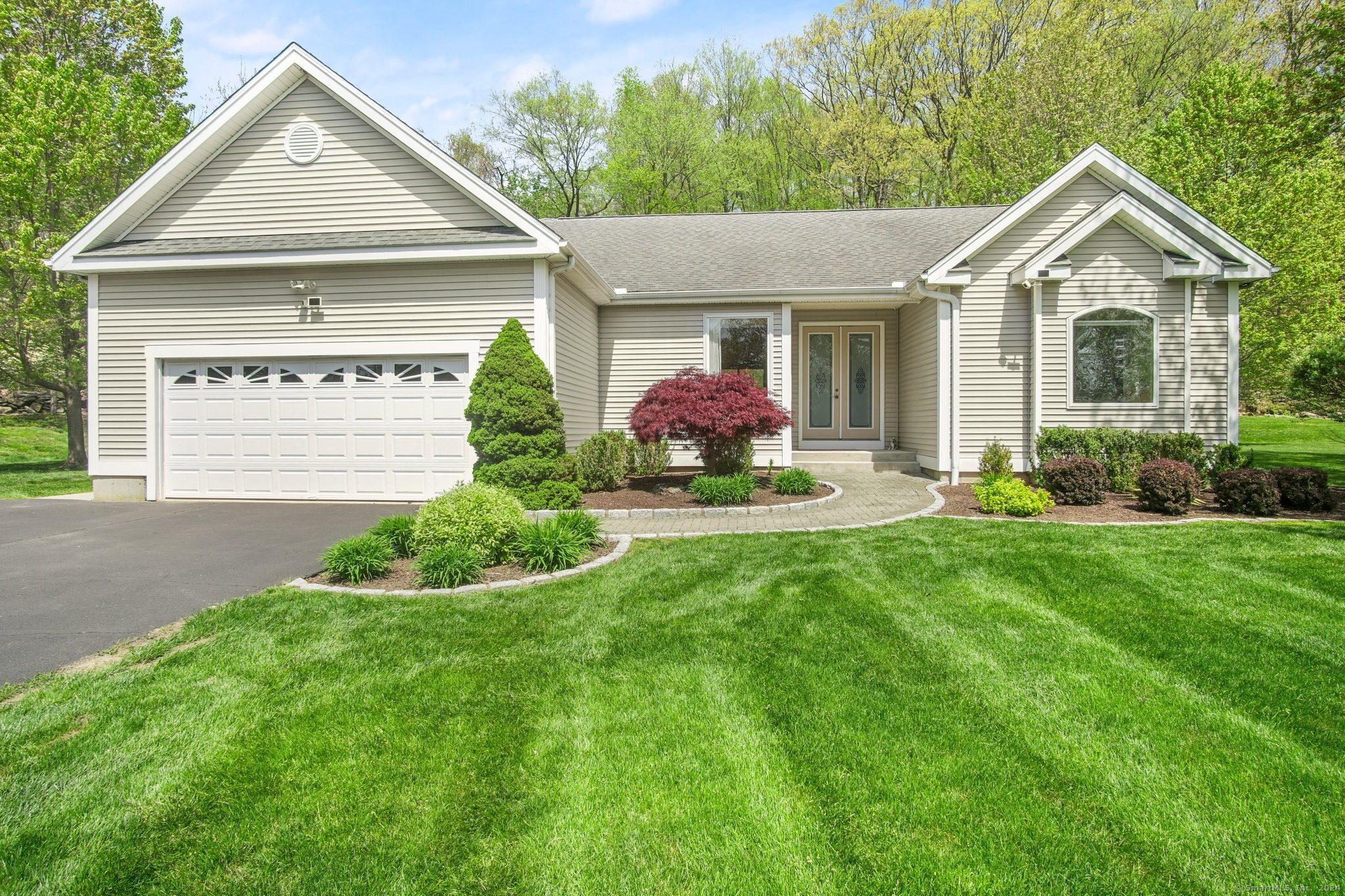 a front view of a house with a garden and plants