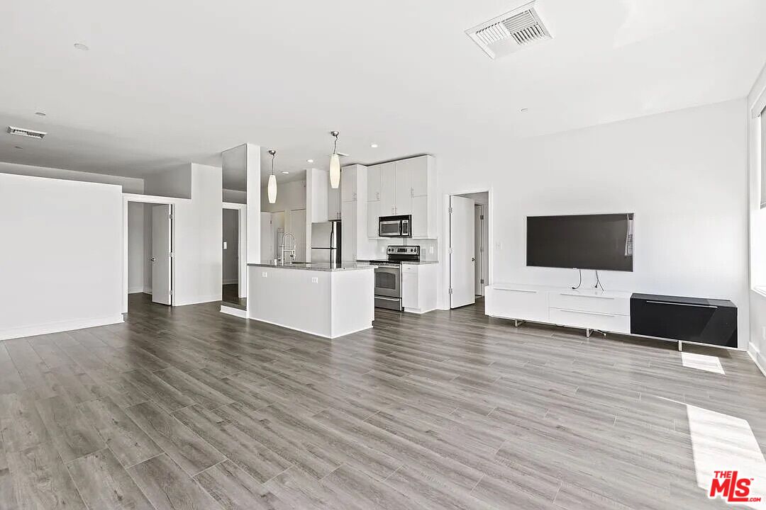 a view of a living room with furniture and wooden floor