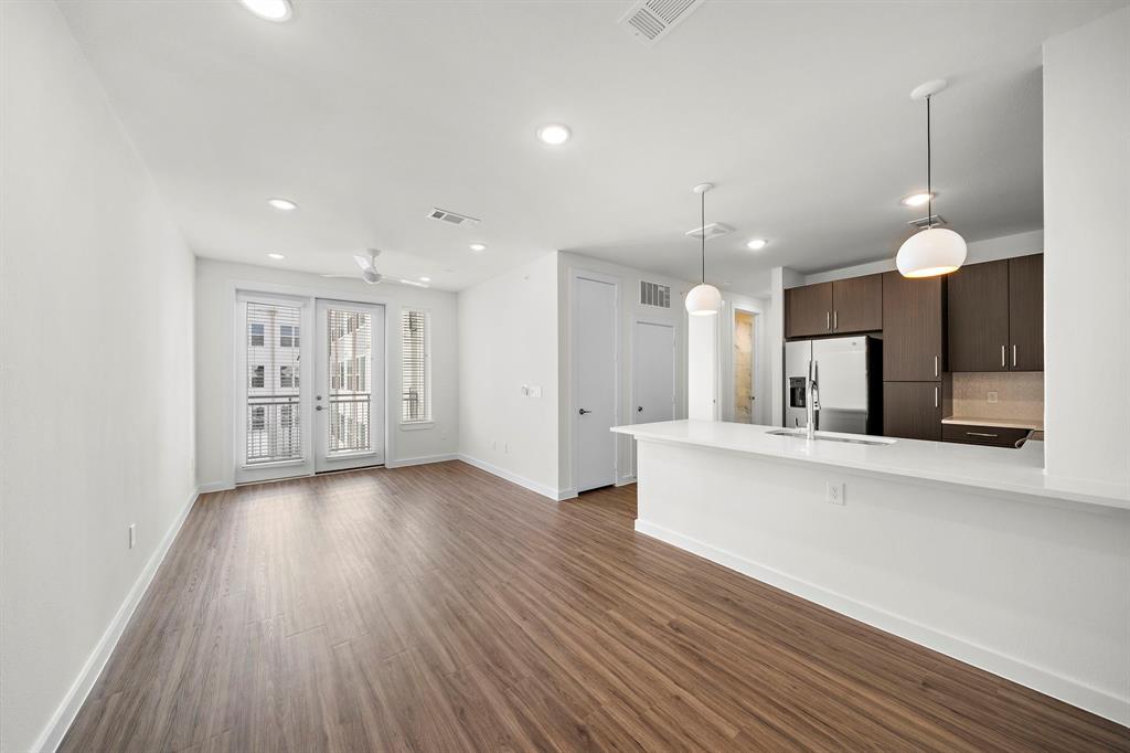 wooden floor in an empty room with a kitchen