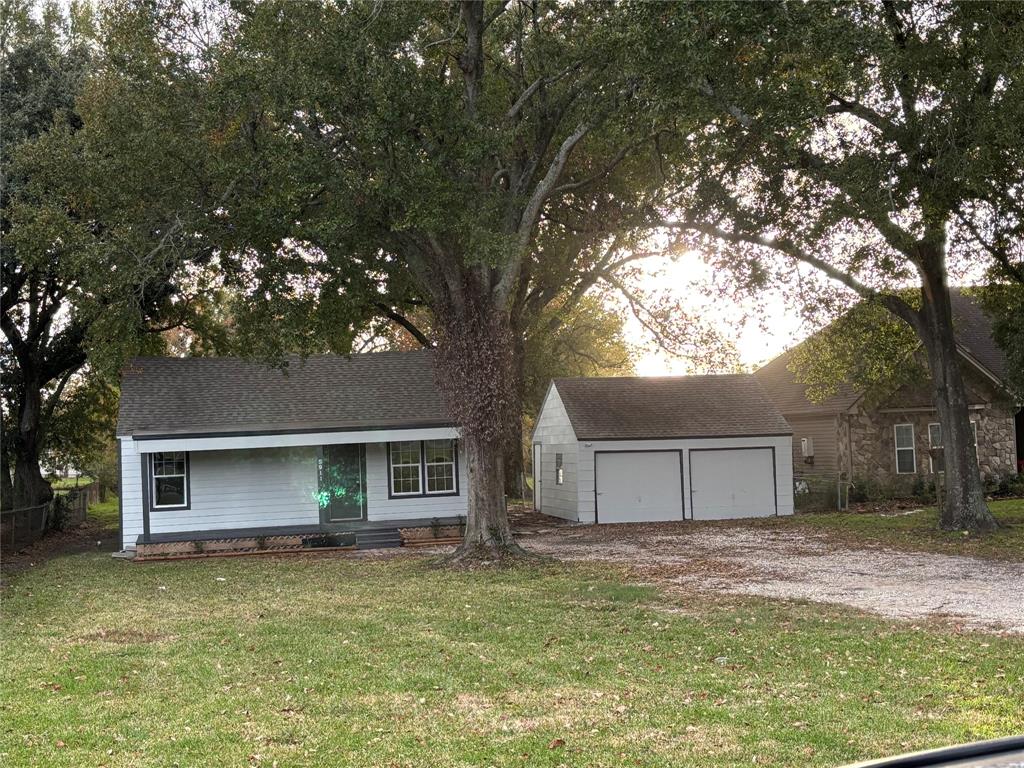 a view of a yard in front of a house with large tree