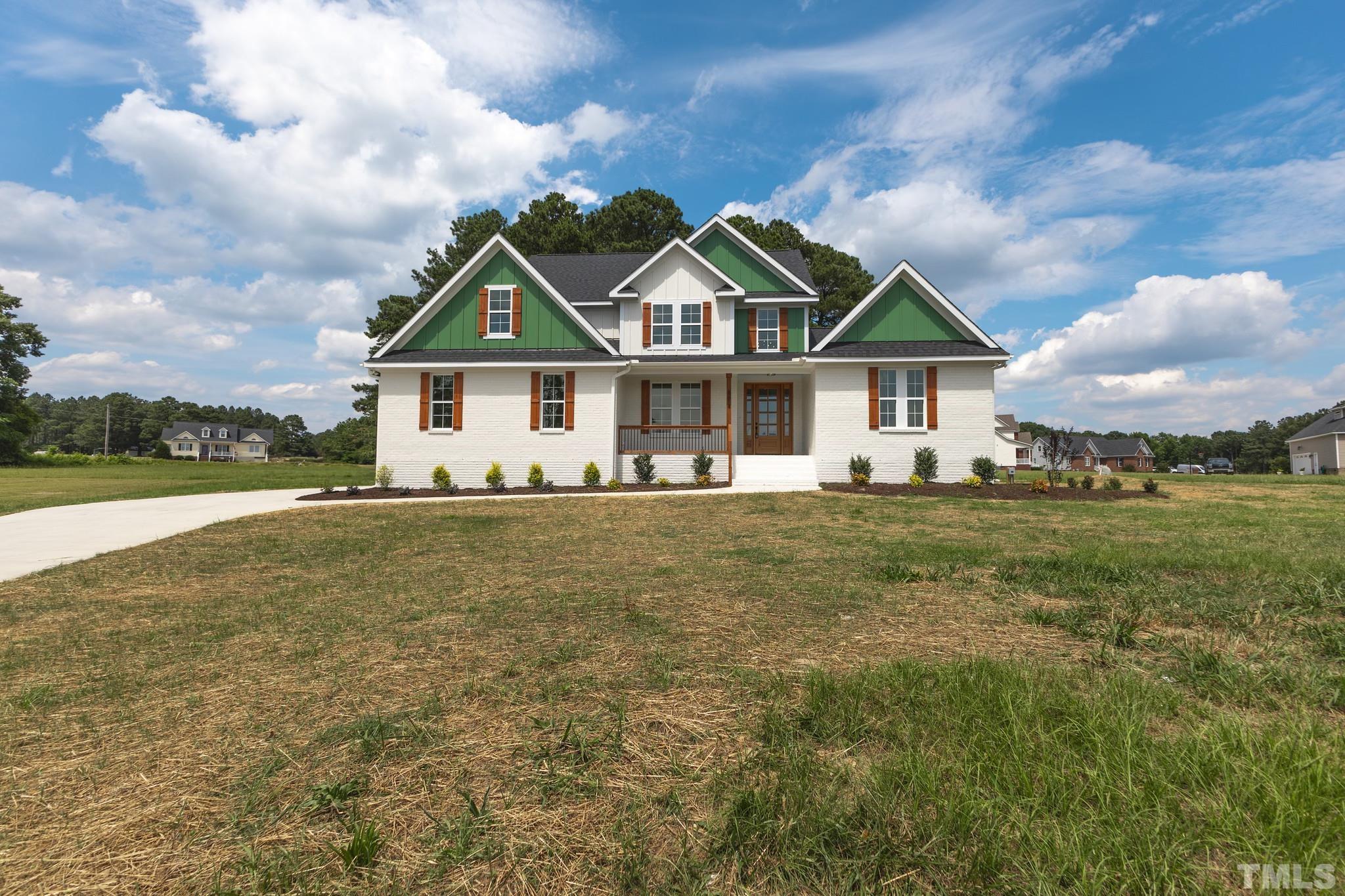 a front view of house with yard and green space