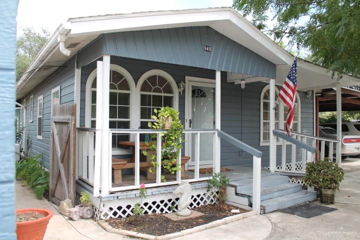 View of outdoor structure featuring a carport and covered porch