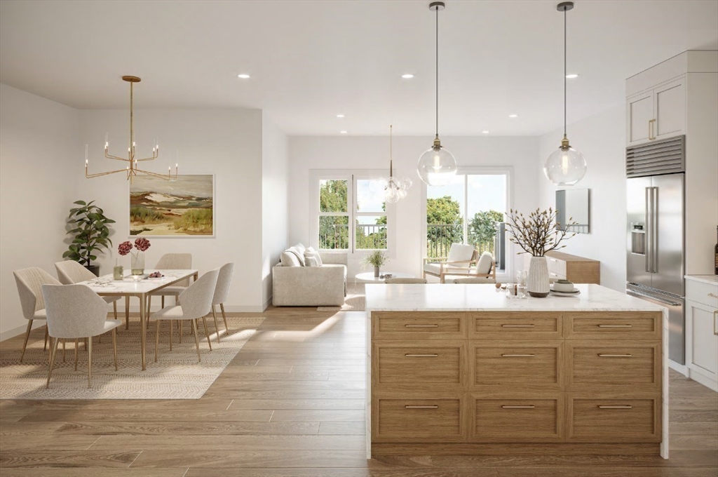 a kitchen with kitchen island granite countertop a stove a dining table chairs and white cabinets