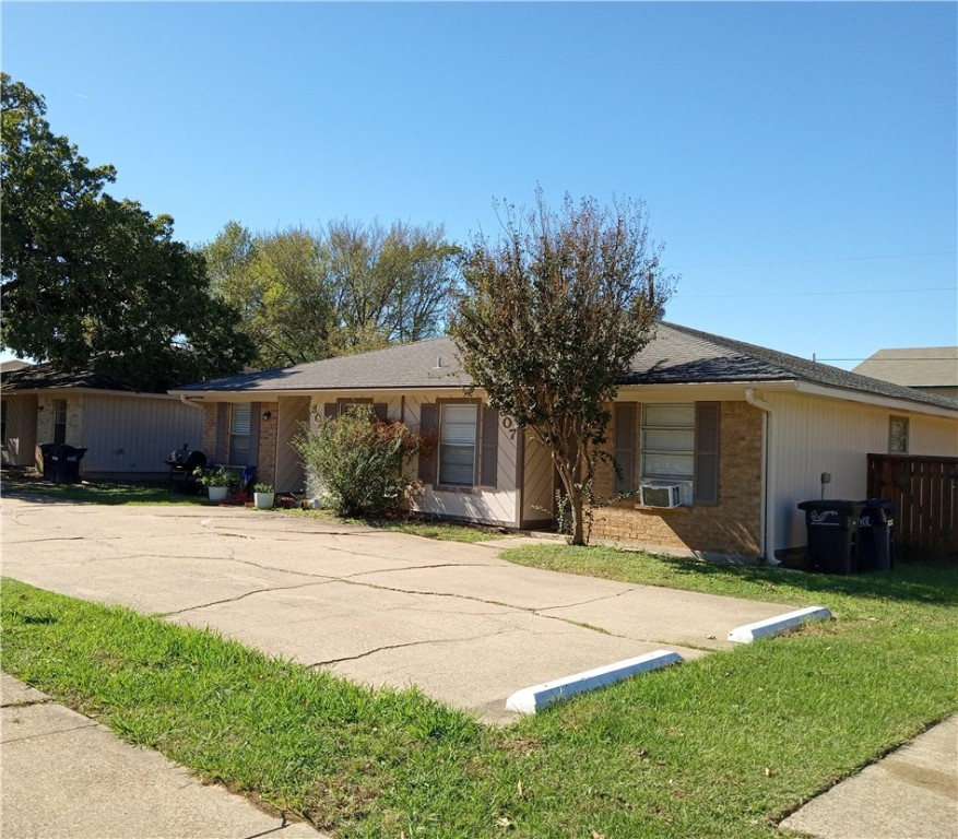 Ranch-style home with cooling unit and a front law