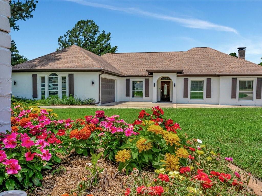 a front view of house with yard and flowers around