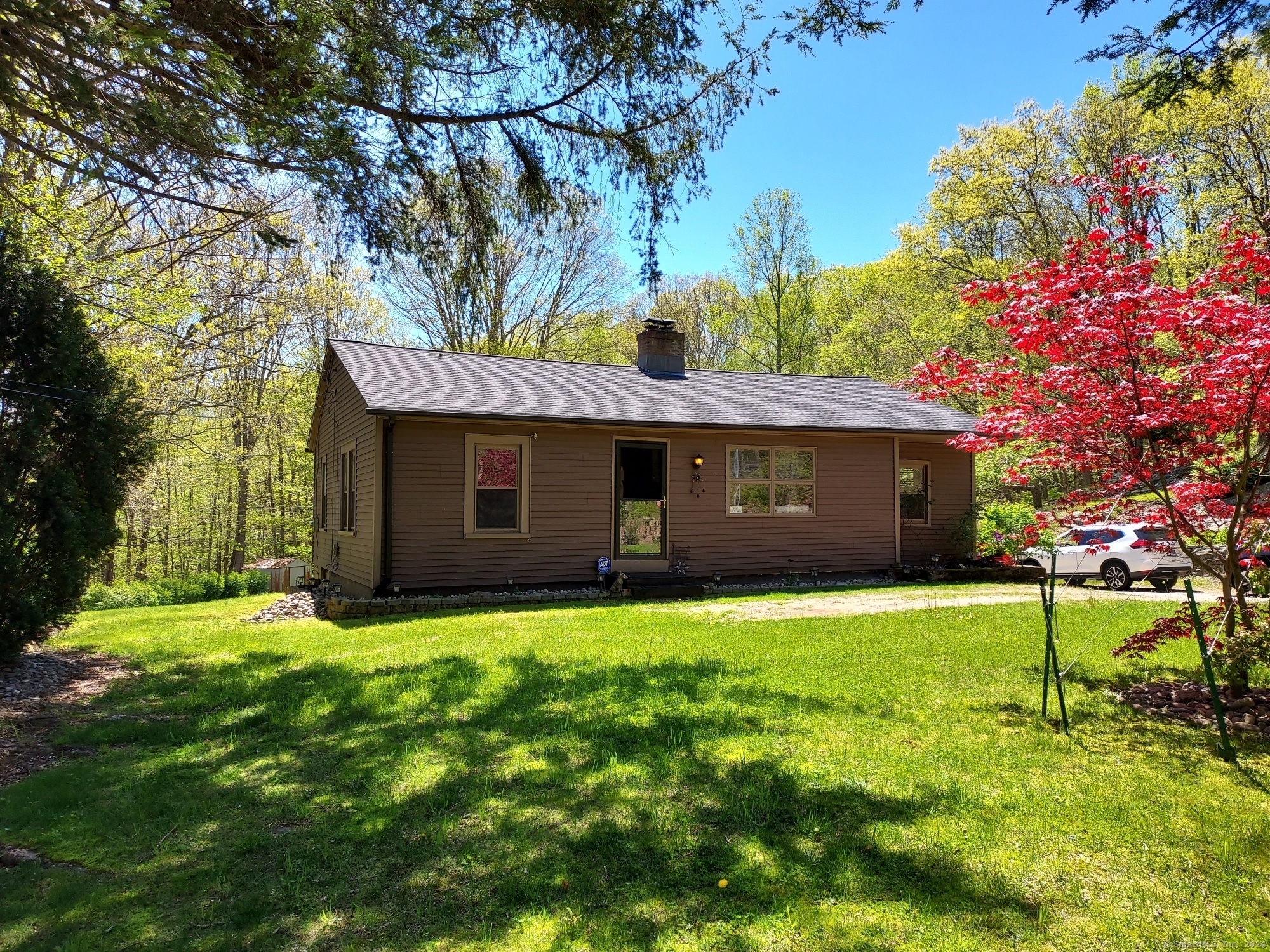 a front view of a house with a yard and trees