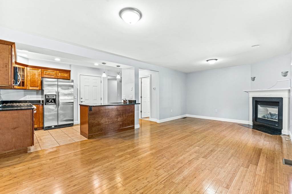 a view of empty room with wooden floor and fireplace