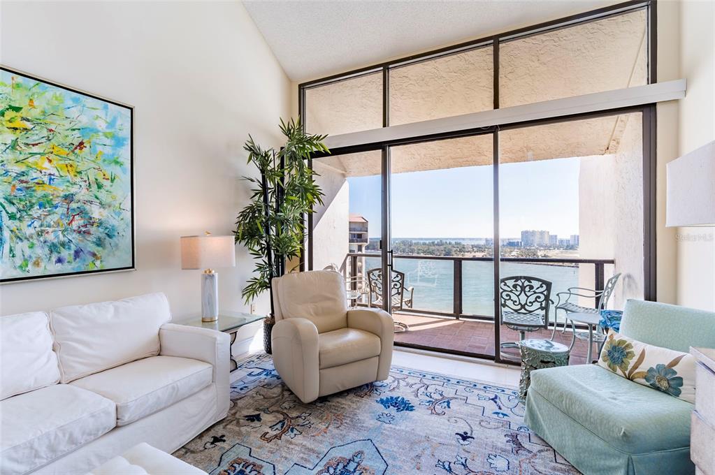 a living room with furniture large window and wooden floor