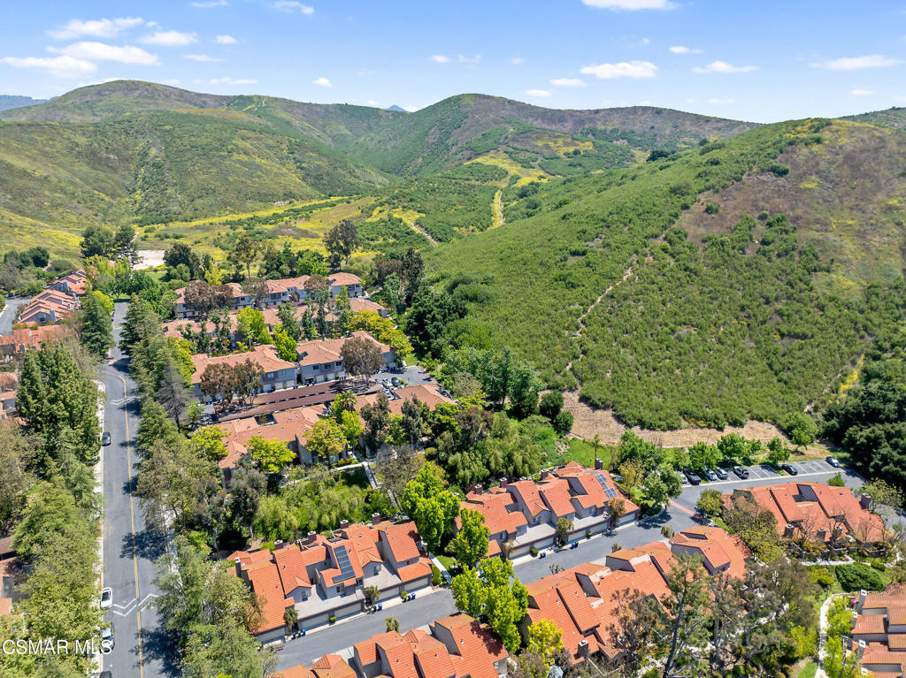 an aerial view of residential houses with outdoor space and trees