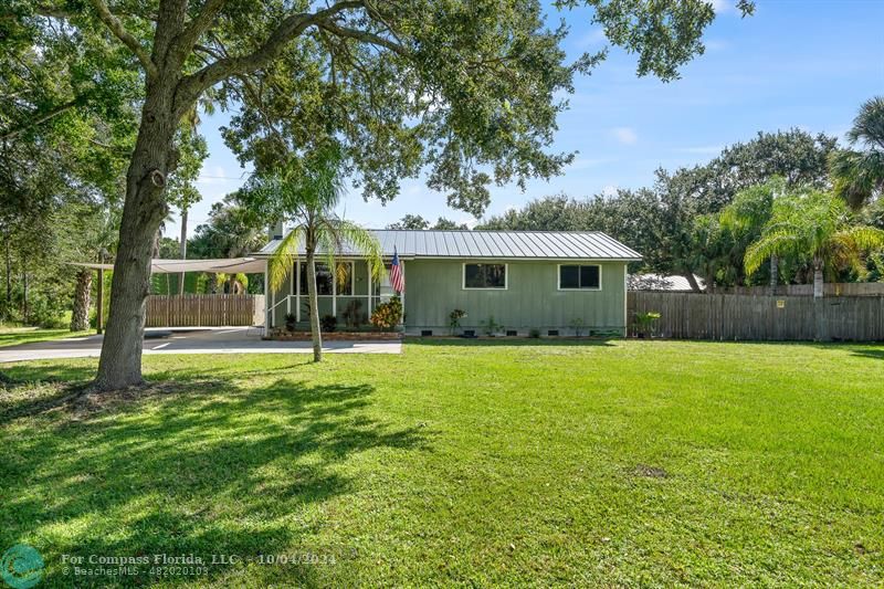 a view of a house with backyard and a tree