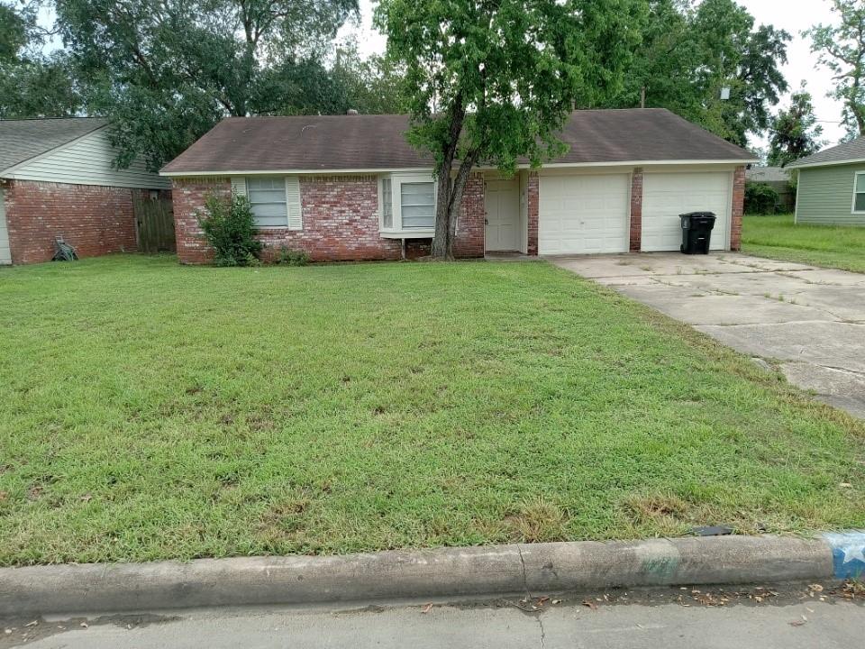 a front view of a house with a garden and yard