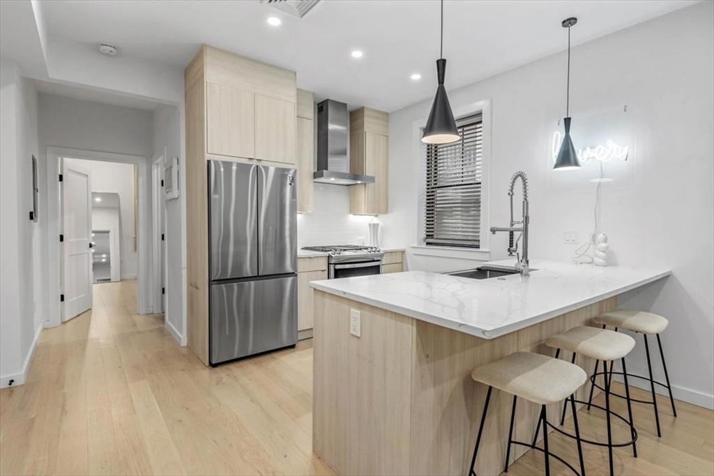 a kitchen with stainless steel appliances kitchen island a refrigerator and a sink