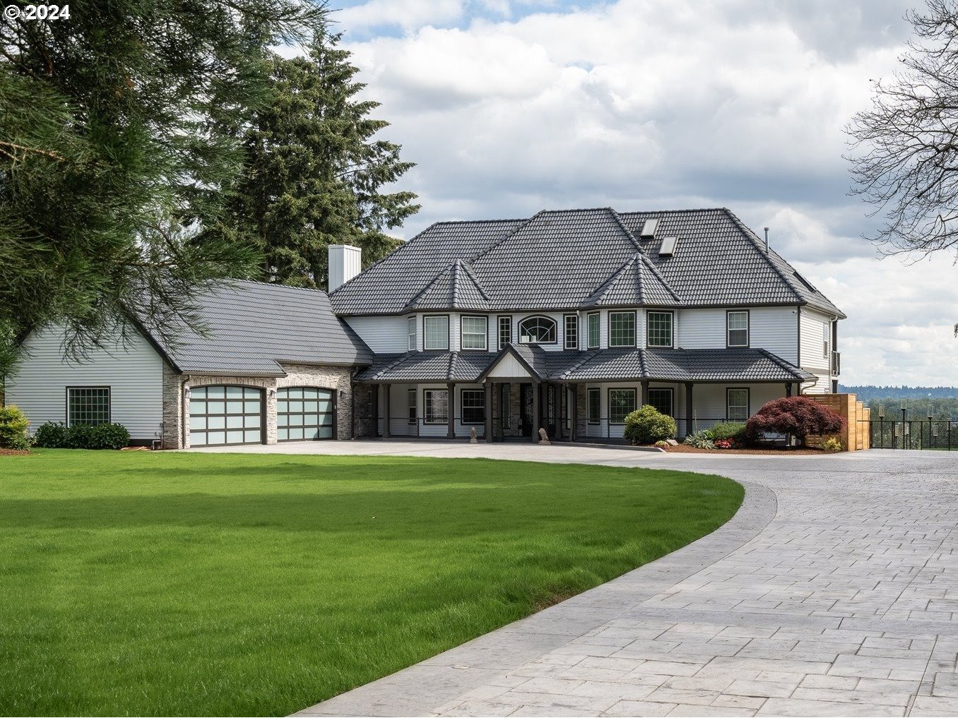 a front view of a house with a yard and trees