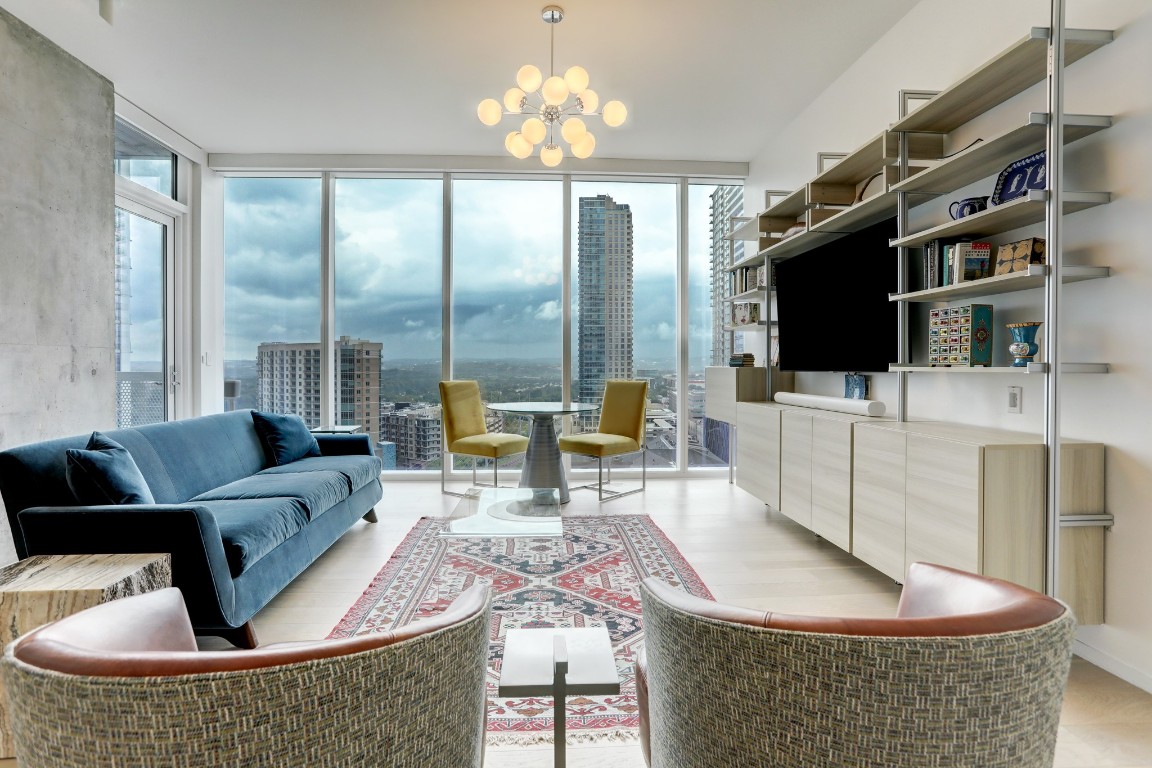 a living room with furniture a flat screen tv and a large window