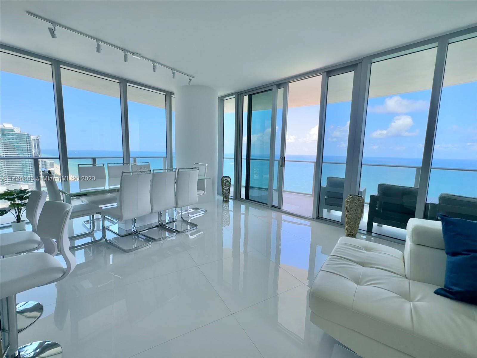 a living room with furniture and large windows