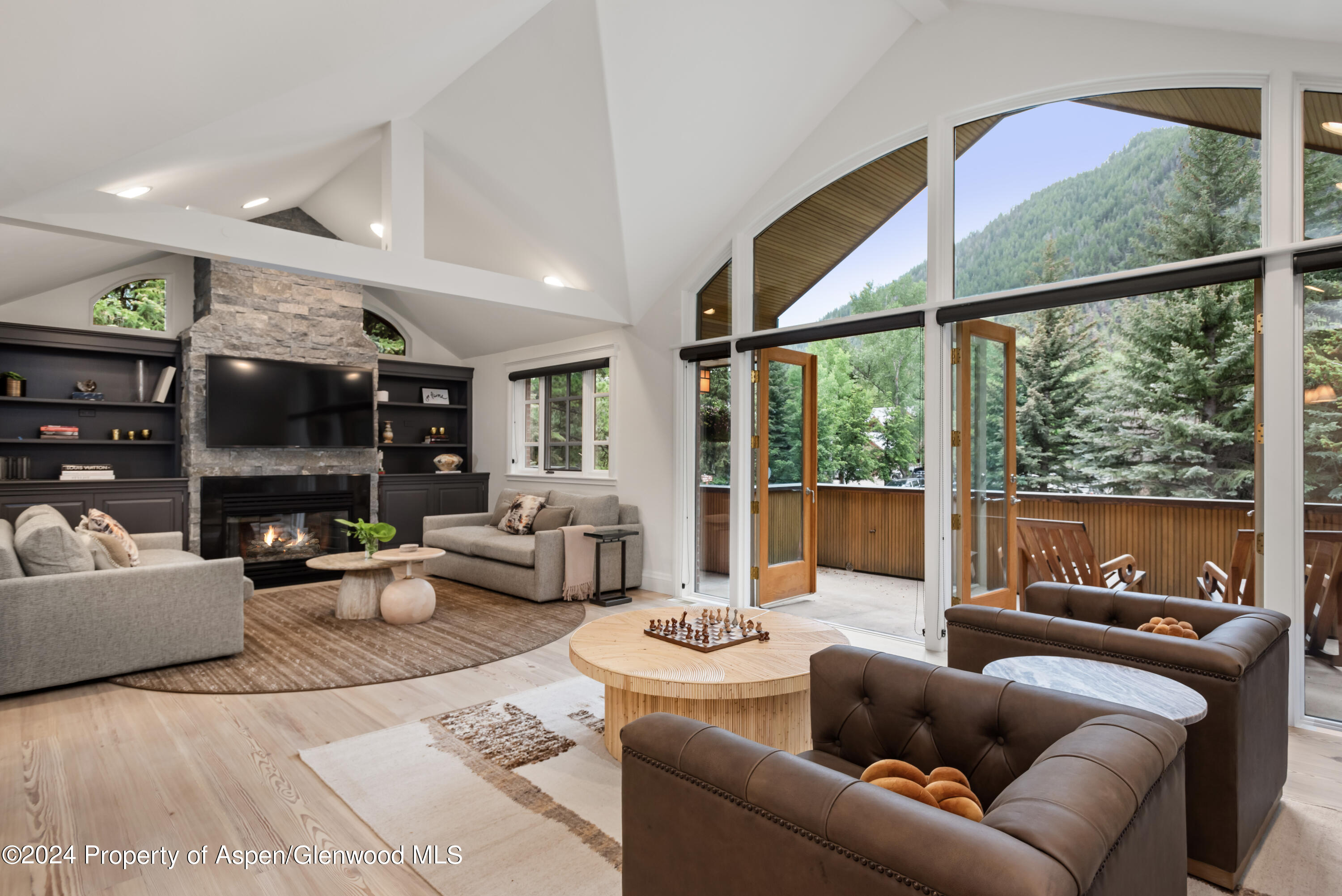 a living room with furniture fireplace and a large window