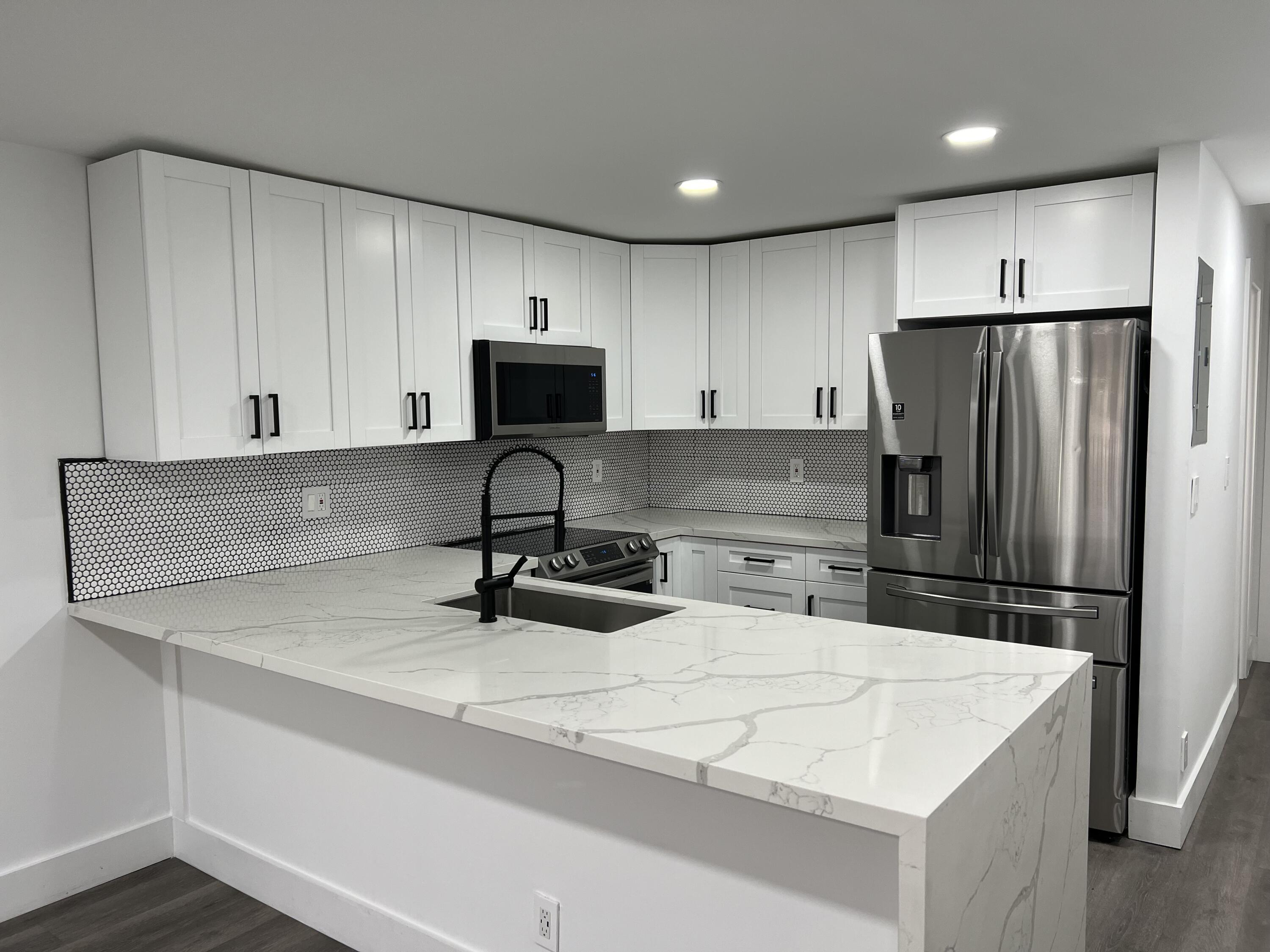 a kitchen with appliances a sink and a refrigerator