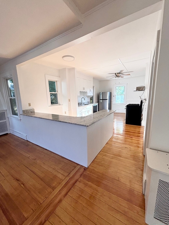 a living room with stainless steel appliances kitchen island granite countertop furniture and a large window