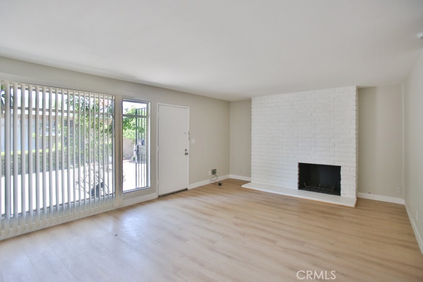 wooden floor fireplace and windows in an empty room