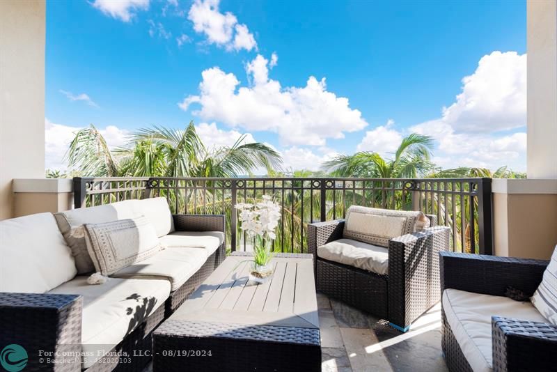 a roof deck with couches and potted plants