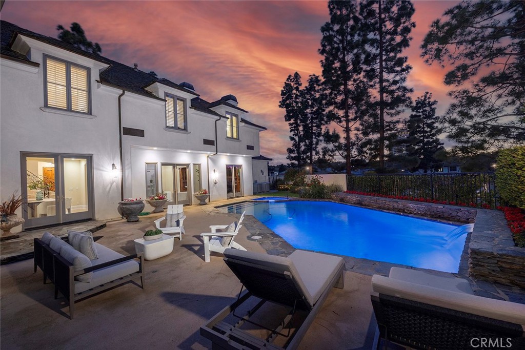 a living room with patio furniture and a fire pit