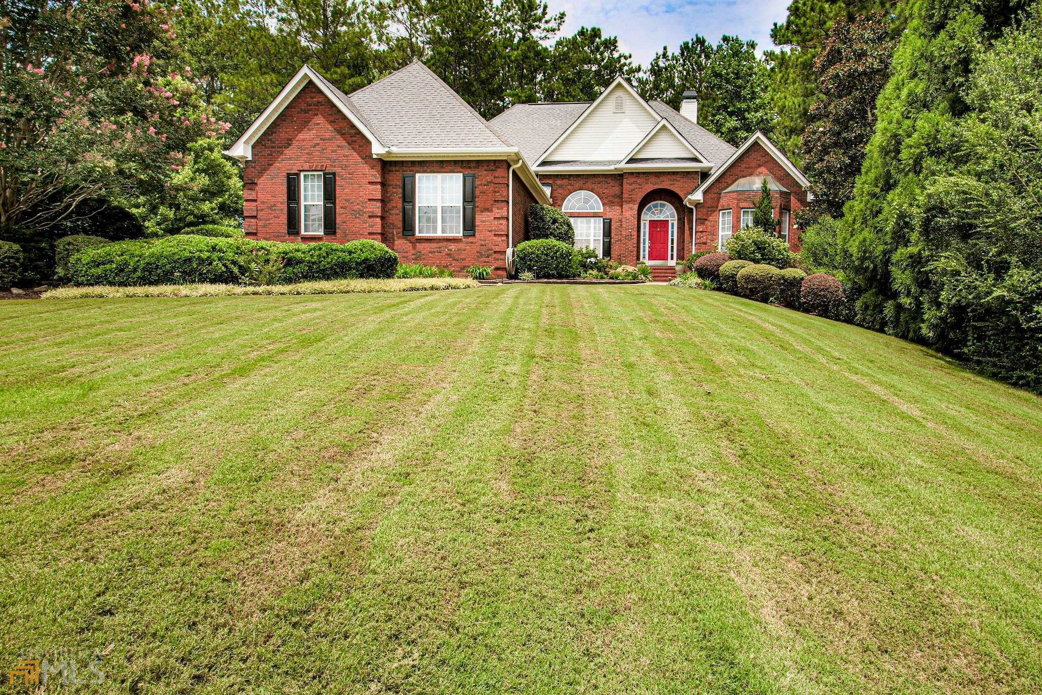 a view of a house with yard and large trees